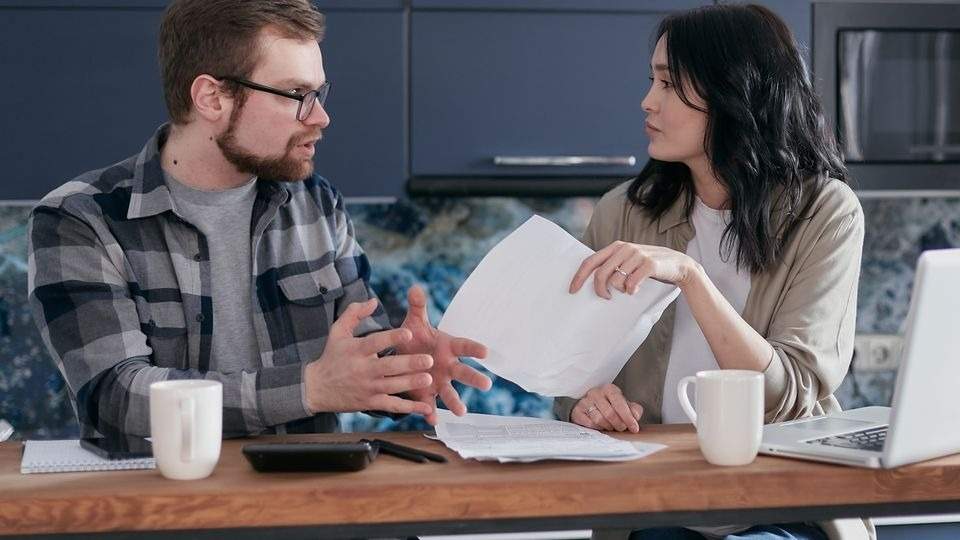 Two adults at a kitchen table talking through attachment difficulties in adults
