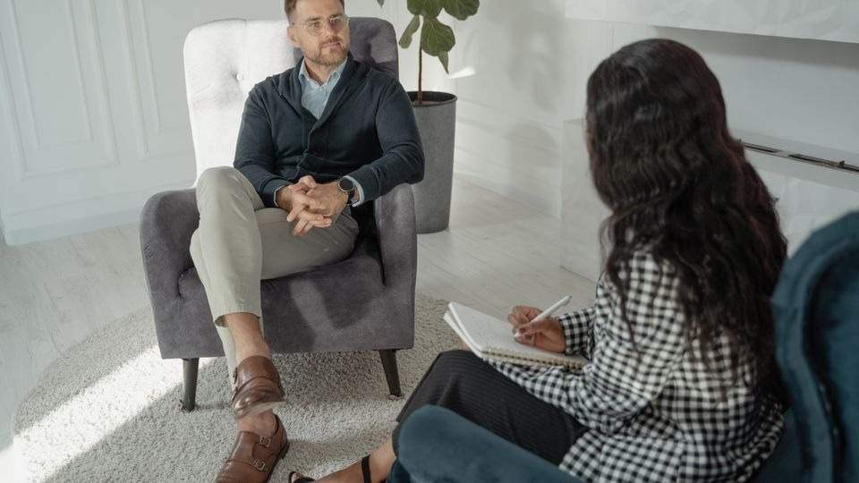 Man meeting a therapist to discuss treatment for attachment issues as an adult